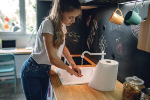 woman washing hands in her kitchen