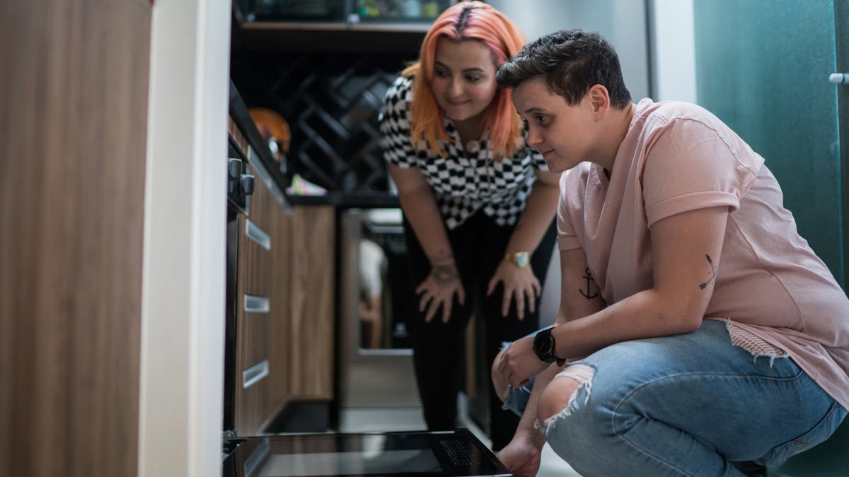 two people looking at their appliances in the kitchen
