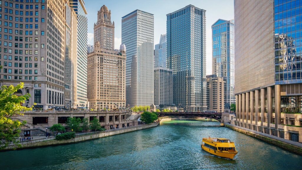 riverboat floating down river in the city of chicago