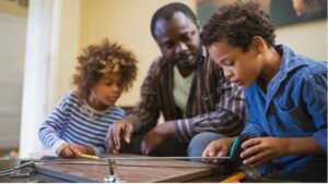 father and two children doing crafts