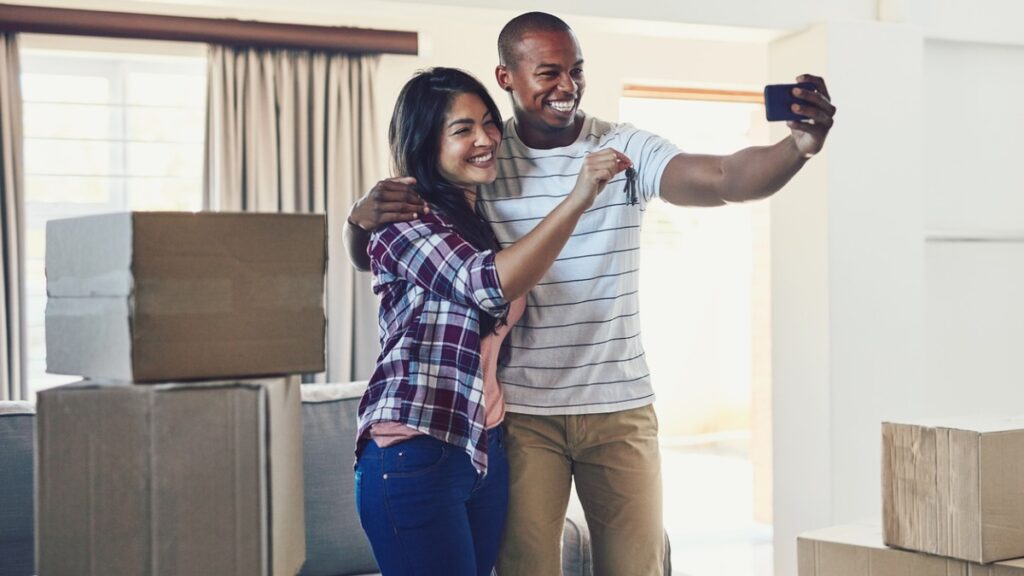 couple taking a selfing holding their new house keys