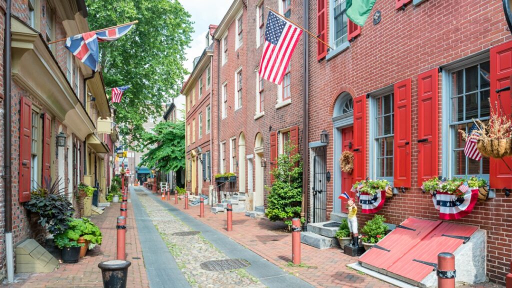 street of brownstone houses with American flags
