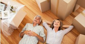 older couple laying surrounded by moving boxes