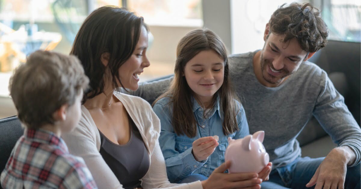 family sitting on couch with piggy bank