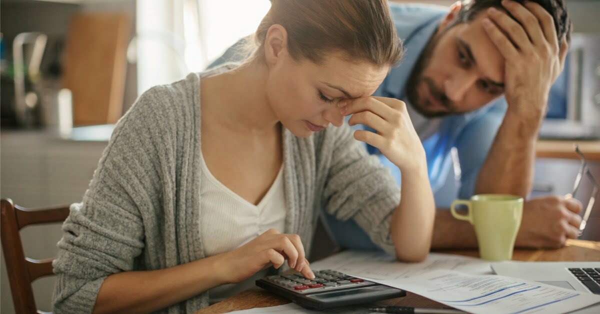 couple looking stressed with calculator