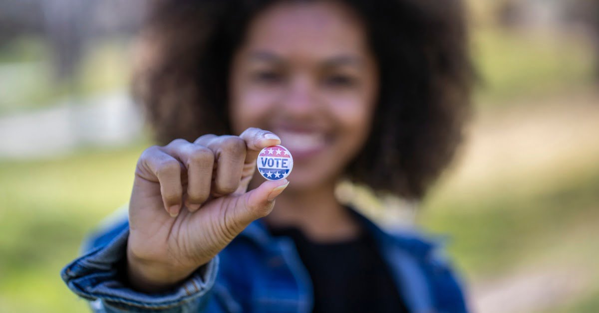 woman holding voter pin