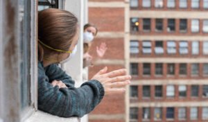 neighbors with face masks waving from a distance