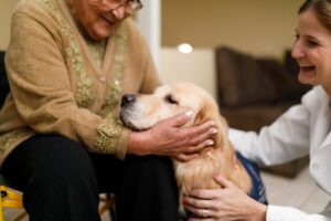 two women petting a dog