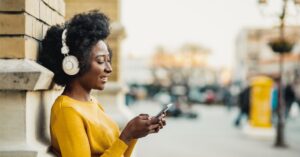 woman smiling at phone with headphones