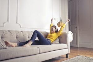 woman on couch listening to headphones