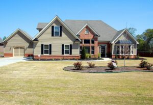 large house with garage and grass yard