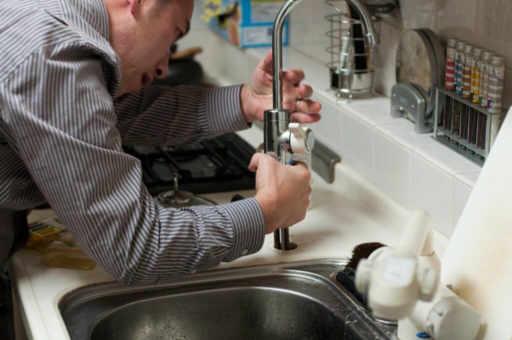 man fixing kitchen sink