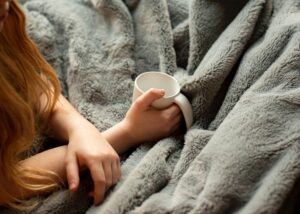 hand holding mug on fuzzy blanket