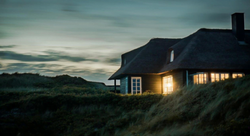 house with lights on at dawn