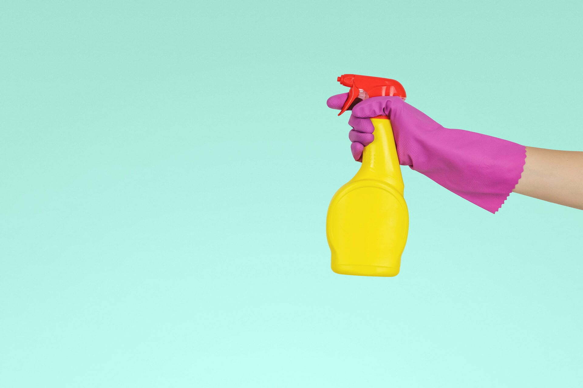 gloved hand holding spray bottle