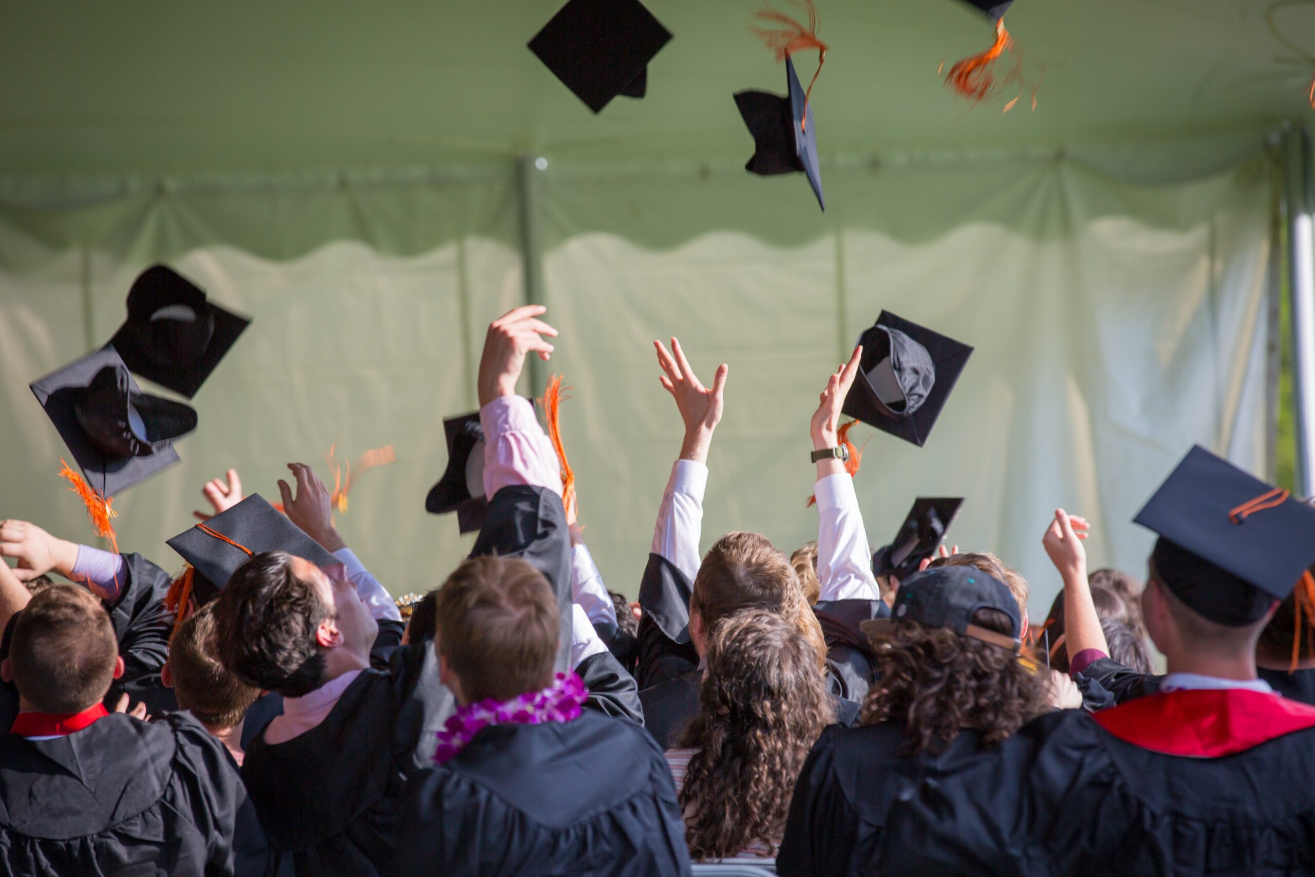 graduates throwing caps during graduation