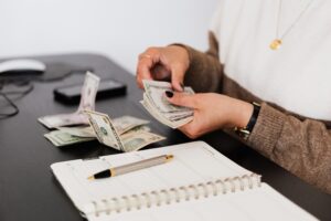 person counting money at desk