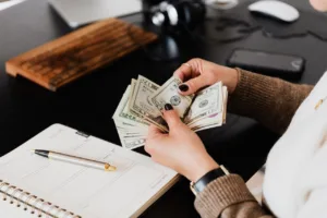 person counting money at desk